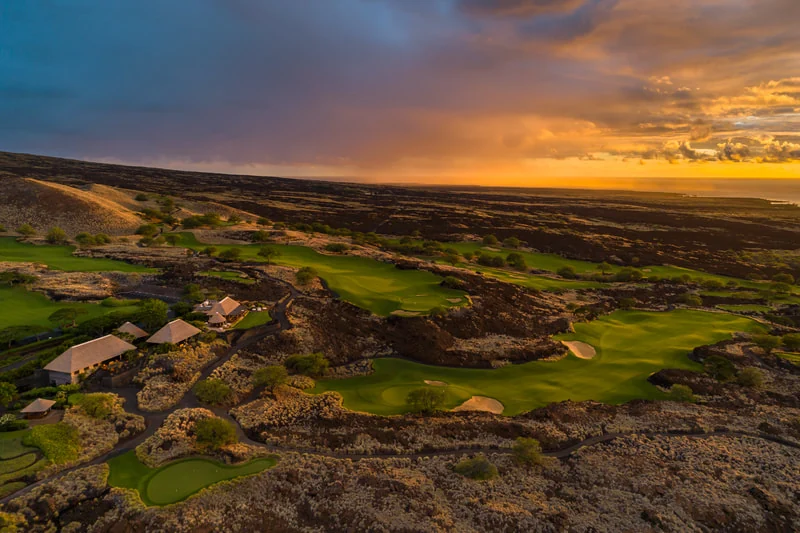Golden sunset over Kūkiʻo golf fairways, lava fields and the Pacific Ocean
